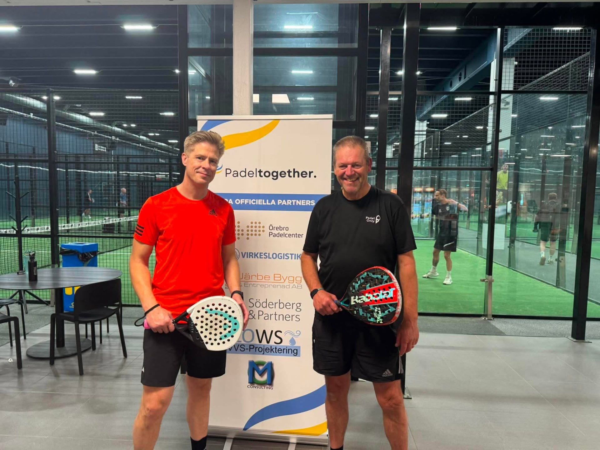 Padeltogether-spelare framför partnerbanner under turnering